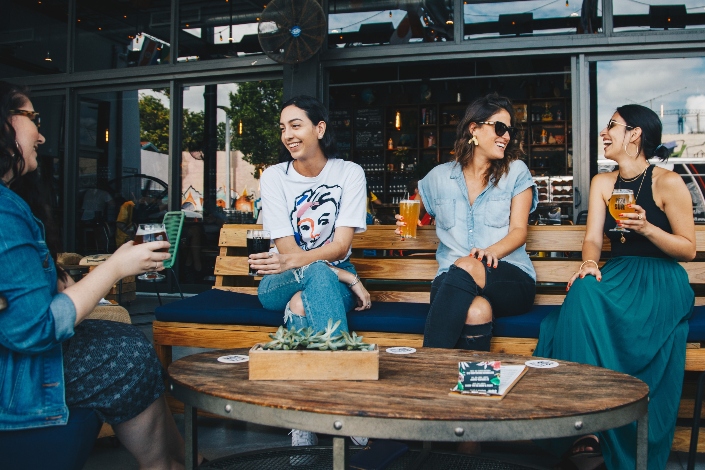 Four women enjoying a beverage on a bar patio