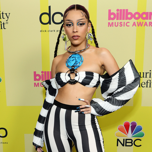 Doja Cat wearing a black and white stripped crop top and fitted pants