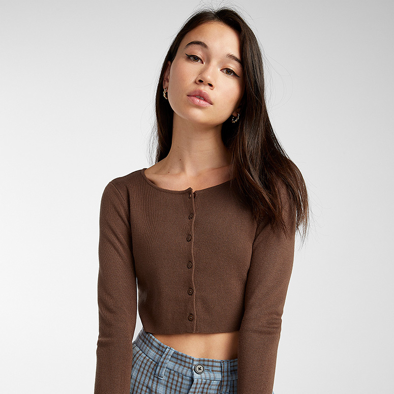 a young Asian woman in a brown cropped cardigan