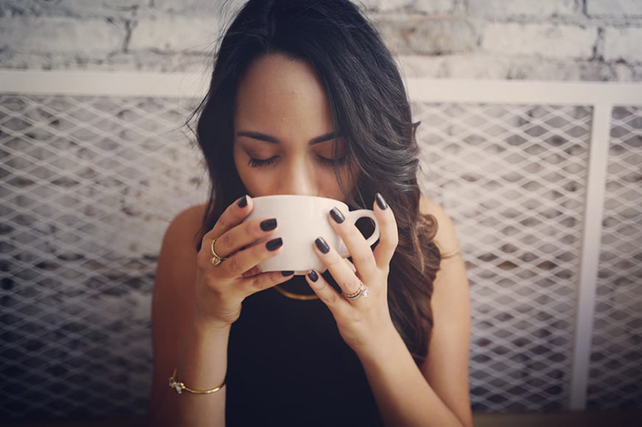 a young woman sipping coffee in a cafe