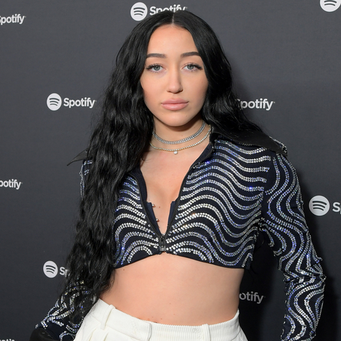 Noah Cyrus wearing a black and white wavy print crop top and white trousers