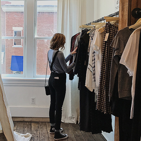 Woman looking through a rack of clothes