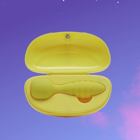 A small yellow vibrator sitting in a charging case