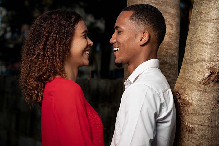 young Black woman and man smiling at each other