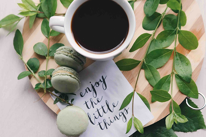 Coffee, macaroons and a note that says 'enjoy the little things'