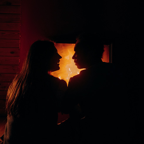 Silhouette of couple sitting in front of fire place
