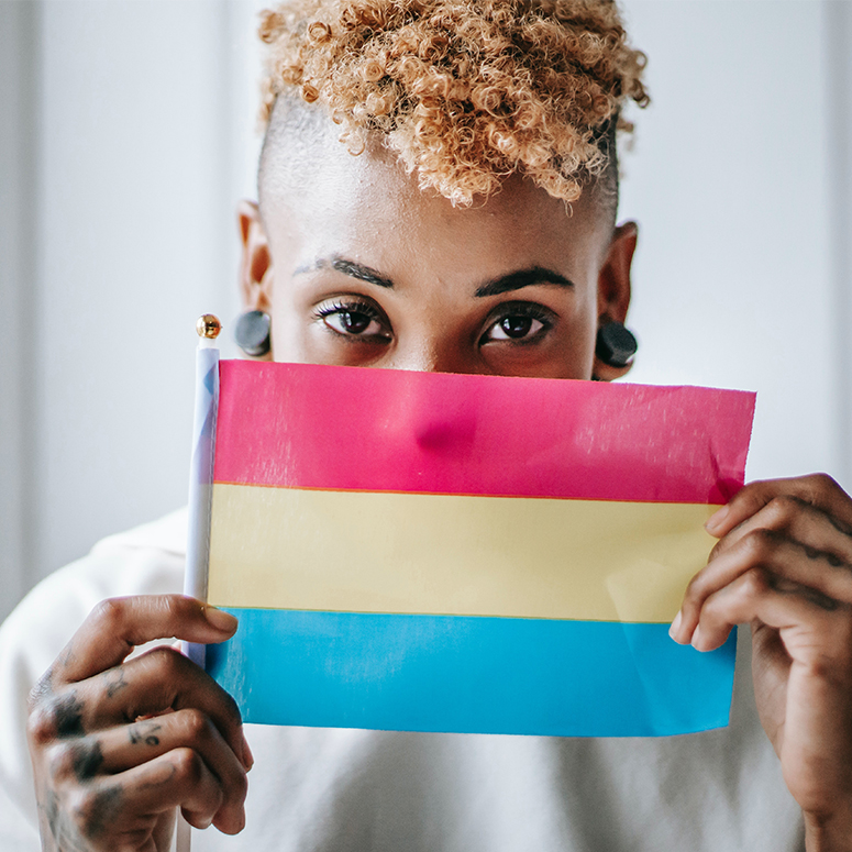 Curly-haired women holding the pansexual pride flag