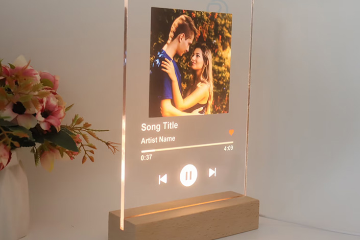 Light up song plaque on a wooden stand.