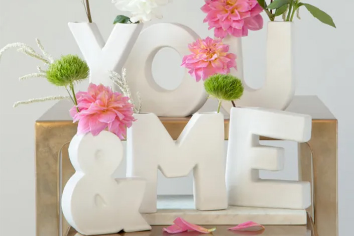 White Vases spelling You & Me with pink flowers inside