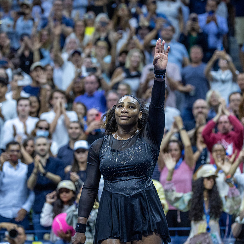 Serena Williams raising her hand up to wave to fans