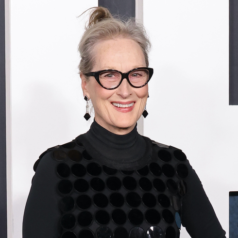 Meryl Streep wearing a dark grey turtle neck with a black dress over top.