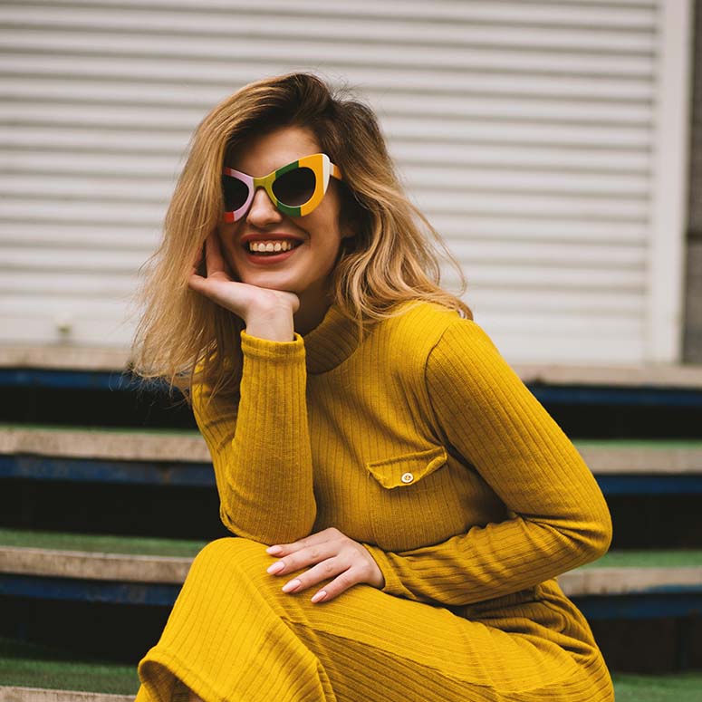young woman wearing a yellow dress and sunglasses