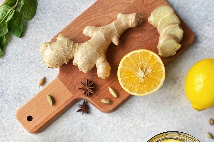 Wooden cutting board with ginger and lemons