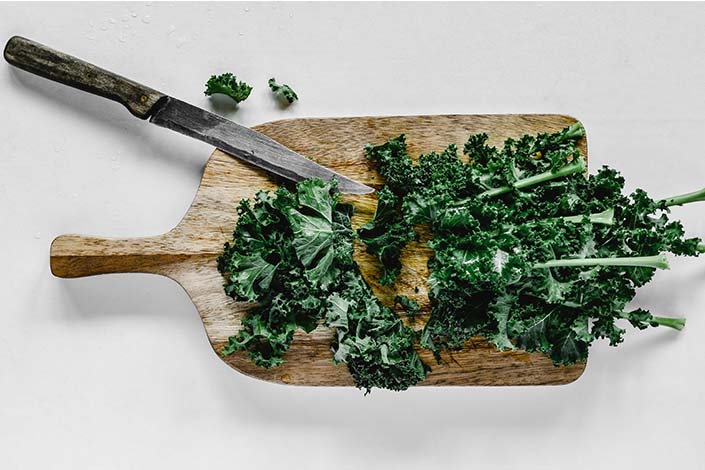Green kale on wooden cutting board
