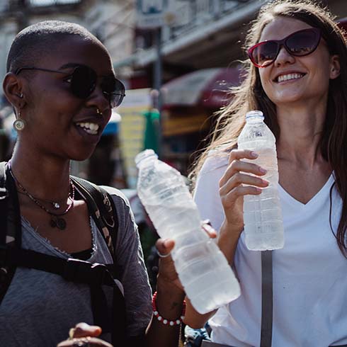Two woman drinking from bottles of water