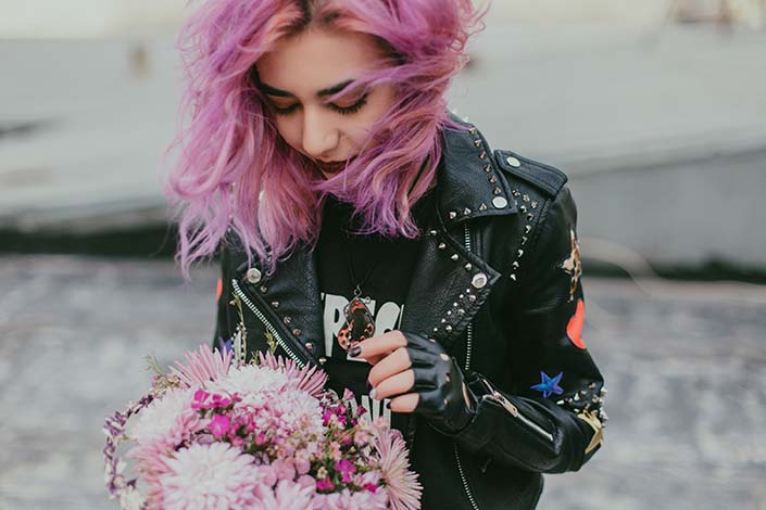 Young woman with pink hair holding flowers