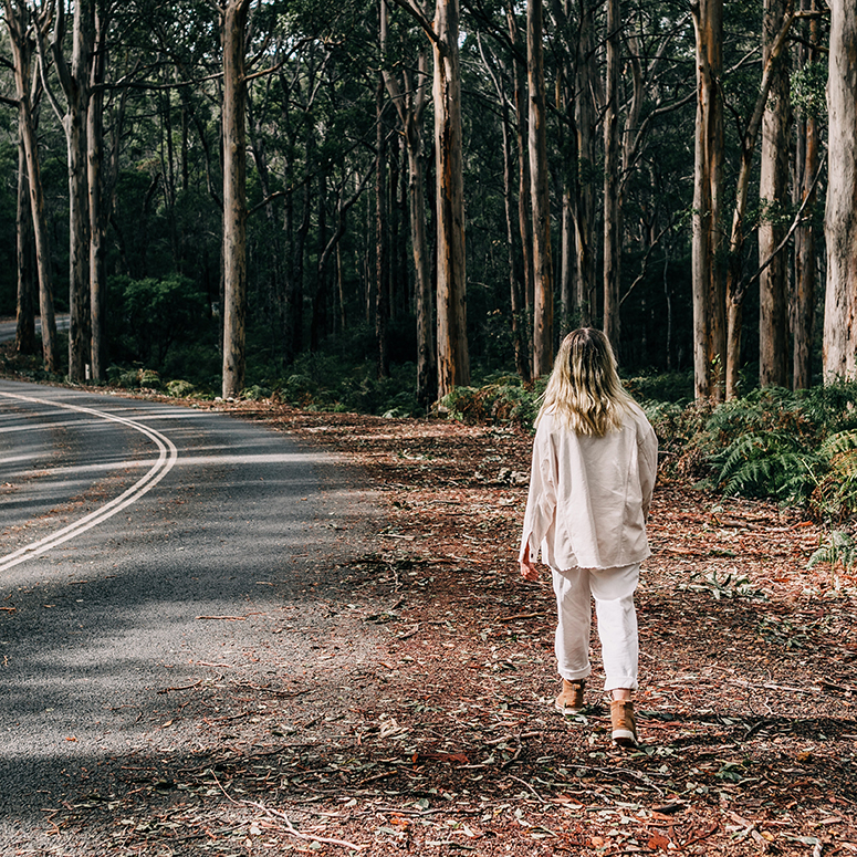 Person walking lonesome alongside a forest road