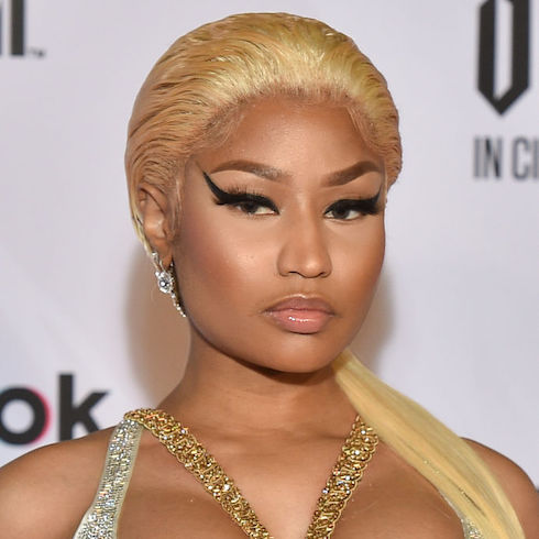 Rapper Nicki Minaj with blonde hair swept back and thick winged liquid liner looking seriously at the camera.