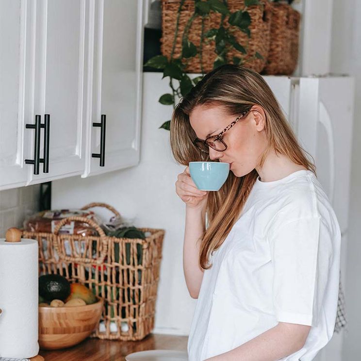 Woman sippling coffee in kitchen