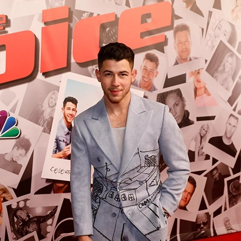 Nick Jonas poses on the red carpet for The Voice.