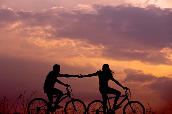 silhouette of a couple on bikes