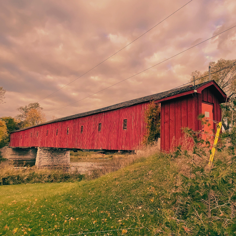 A red covered bridge over a river