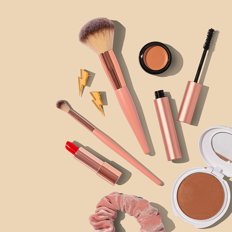 Makeup products on a pale yellow backdrop