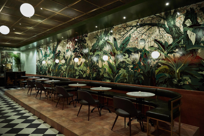 Bar tables and seating against a botanical mural