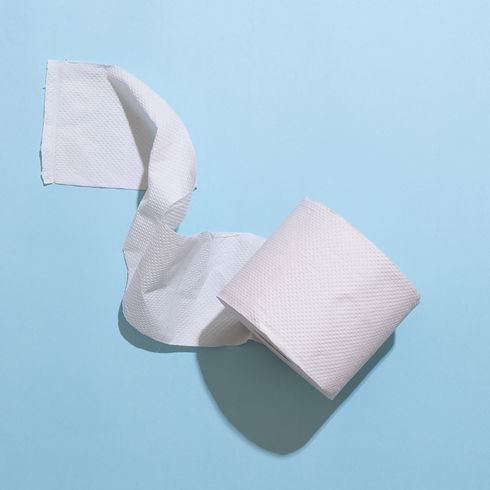 Unravelling roll of toilet paper on a blue background