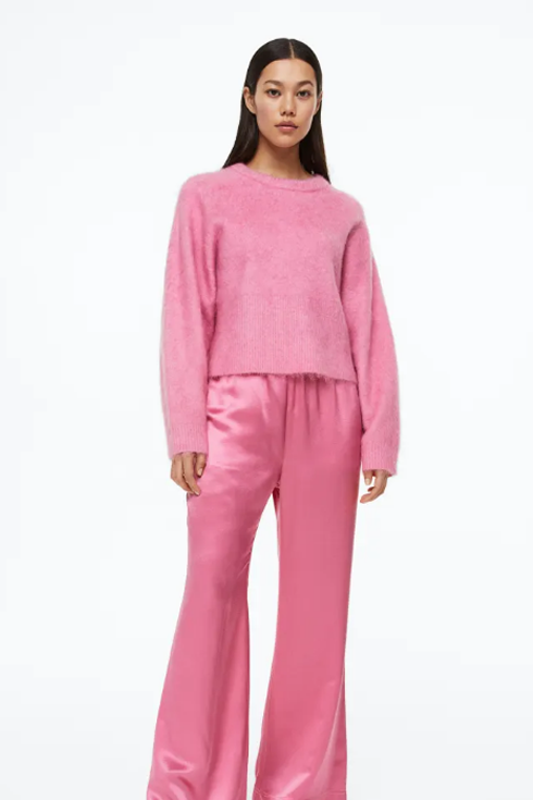 A woman wearing a pink mohair-blend sweater and pink pants
