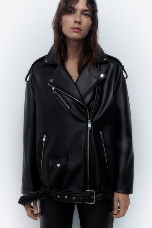 A woman wears an oversized black moto jacket