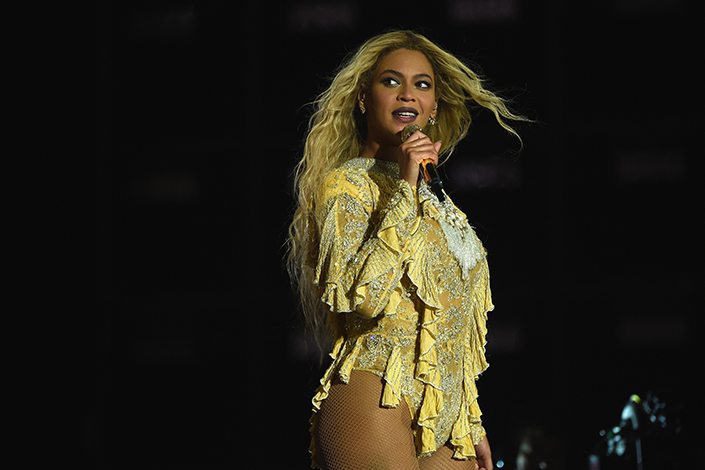 Beyonce performing in a yellow body suit