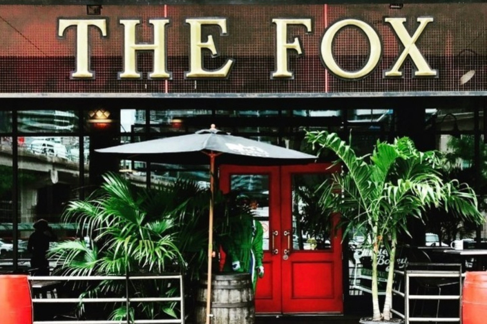 The red door exterior of The Fox pub in Toronto