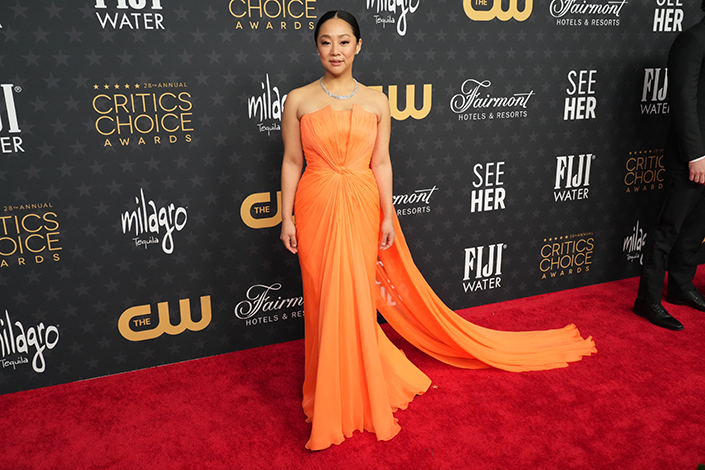 Stephanie Hsu in a draped tangerine gown at the Critics Choice Awards