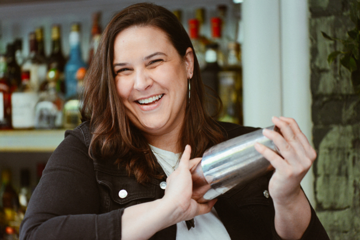 Kate Boushel of the Barroco Group in Montreal shakes a cocktail behind a bar.