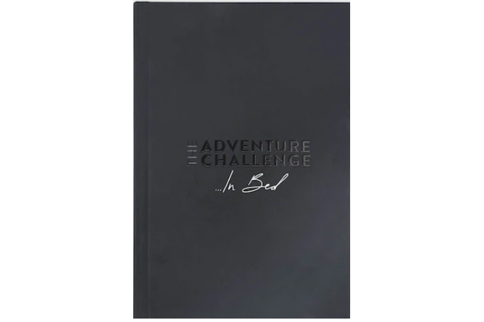 A black book with "Adventure Challenges... In Bed" on the cover