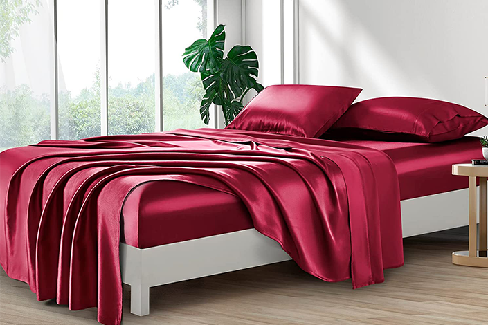 A bed with red satin sheets