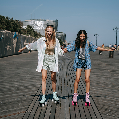 Two young women roller skating together.