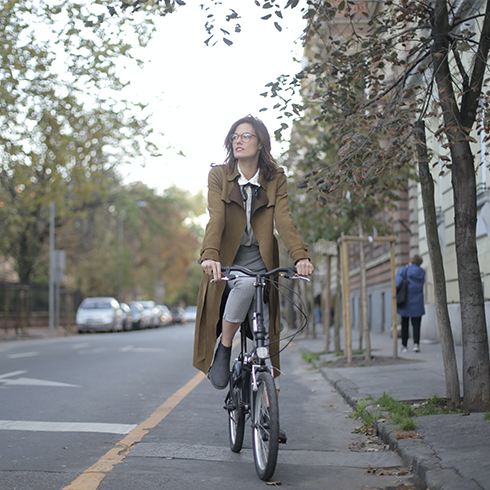 A young woman rides a bike down the street.