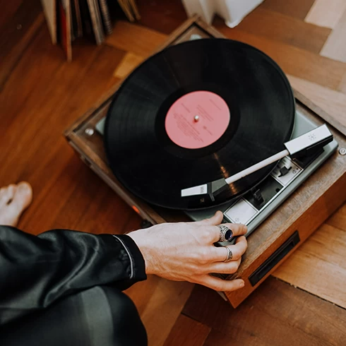 A person putting a vinyl record on a record player