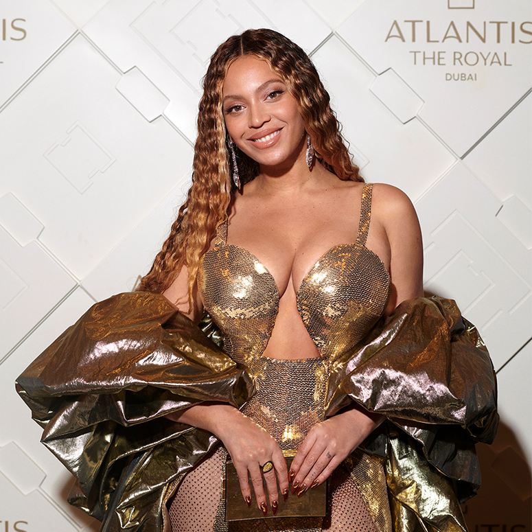 Smiling and wearing a golden outfit, Beyoncé attends the Atlantis The Royal Grand Reveal Weekend, a new ultra-luxury resort on January 21, 2023 in Dubai