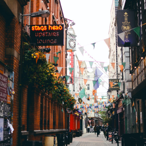 A shot of a street in Dublin Ireland, with pubs and flags seen above