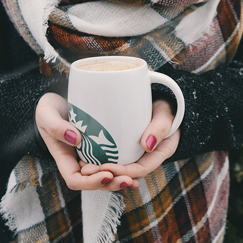 A woman's hands holding a Starbucks mug