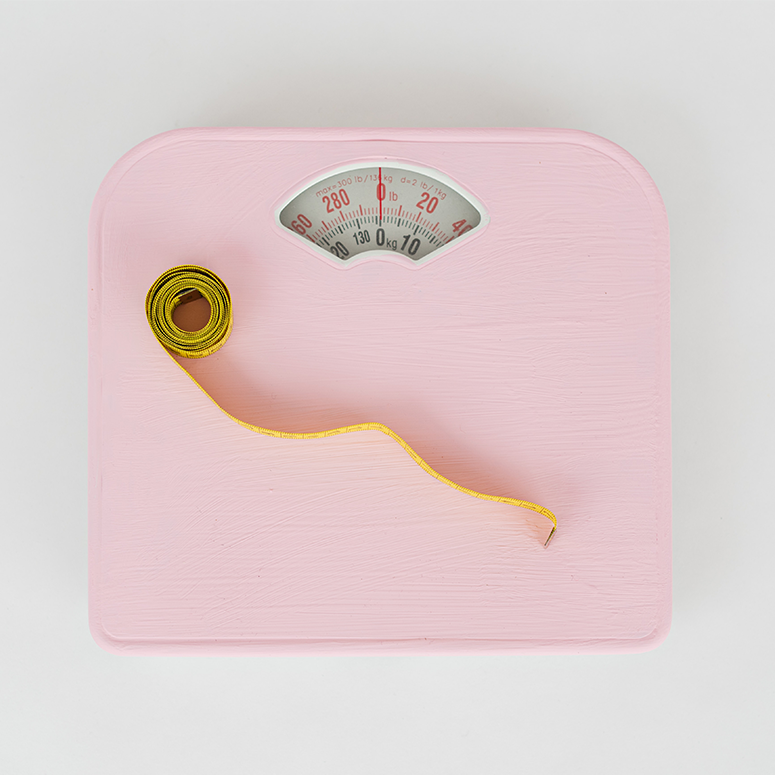 A pink scale with a measuring tap on top