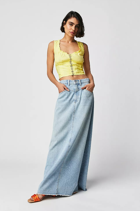 A light wash denim skirt with a slit paired with a yellow tank top