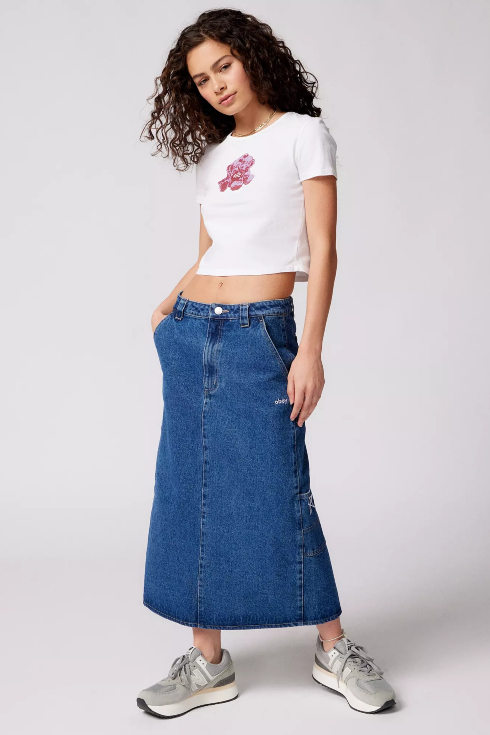 A girl wearing a baby t-shirt and long long-rise denim jean skirt