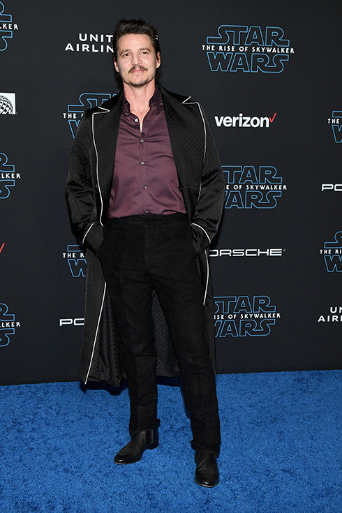 Pedro Pascal wearing a long black silk jacket at a Hollywood event