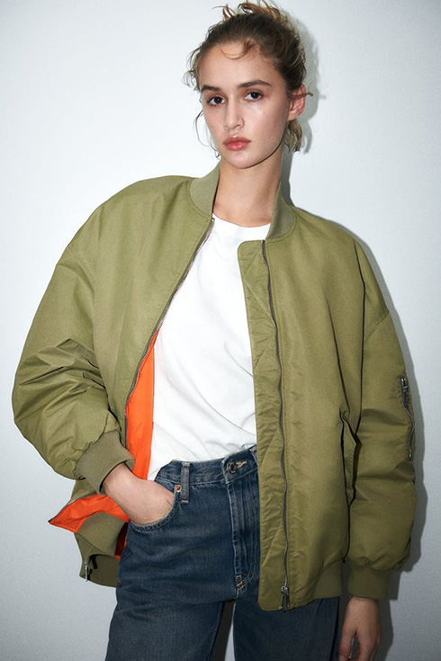 a woman wearing an oversized bomber jacket