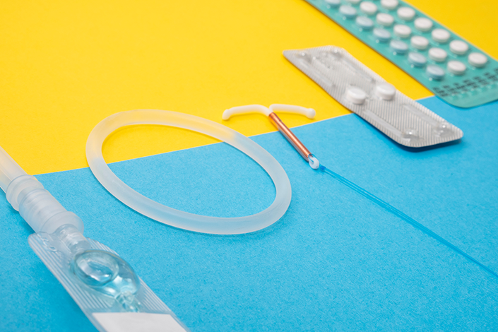 A set of a contraception methods in front of a yellow and blue background