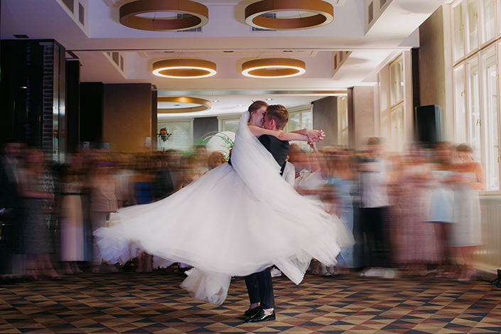 young newlyweds dancing in a blurred wedding photo